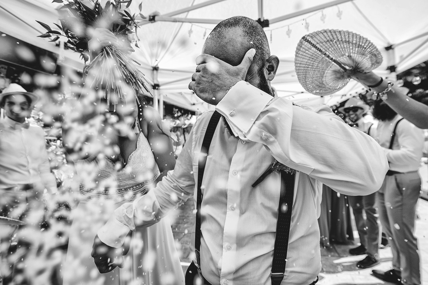 José emocionado, tapándose la cara mientras sostiene la mano de Annabel durante la celebración de su boda en Fuerteventura, rodeados de invitados y pétalos.