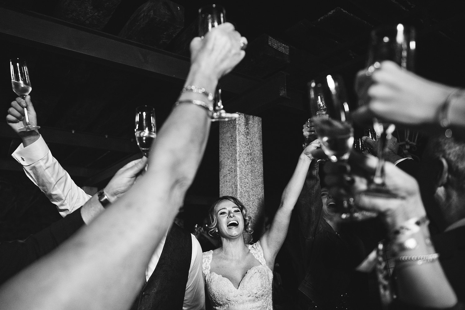 Jara levantando el brazo durante un brindis, rodeada de invitados con copas de champán en su boda en Córdoba.