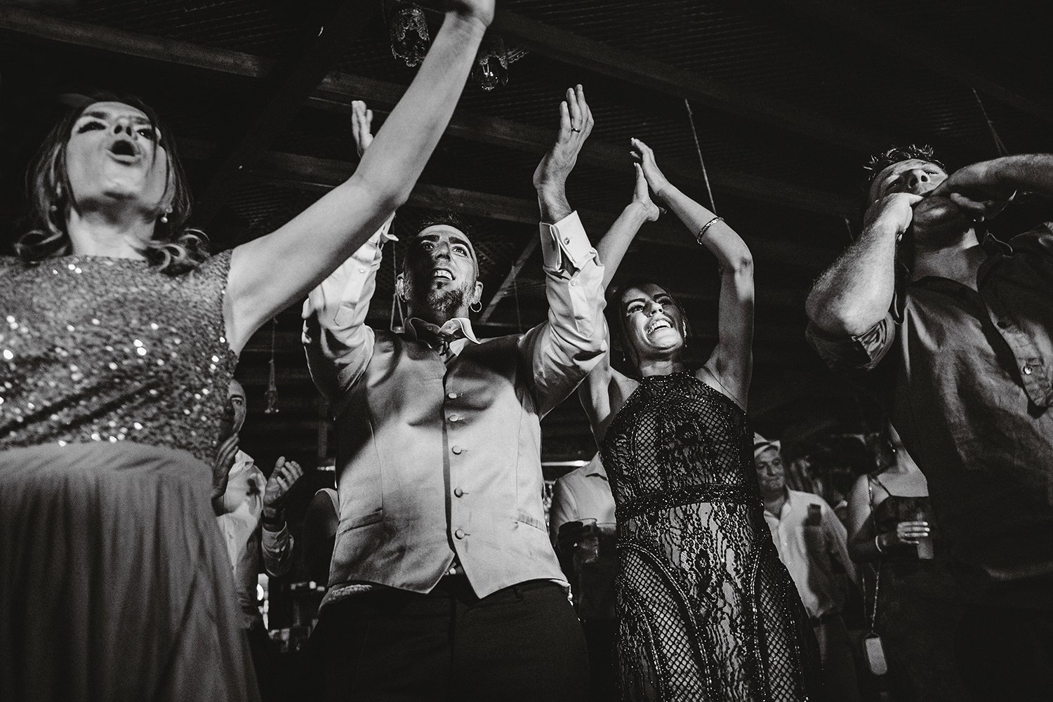 Novios bailando con los brazos levantados, rodeados de invitados durante una fiesta de boda en Sagunto, Valencia.