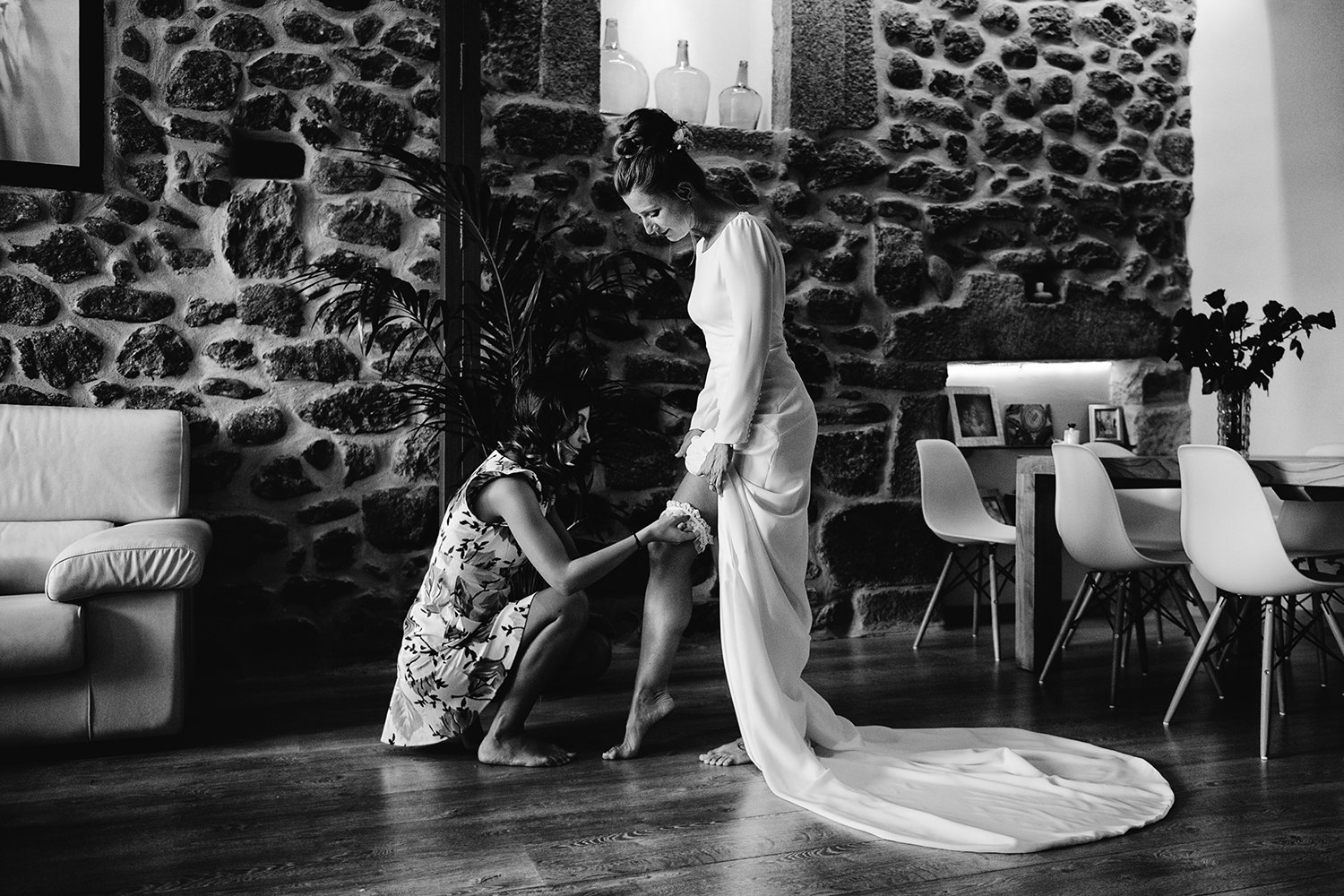 Maud durante los preparativos de su boda en Extremadura, mientras una mujer le coloca la liga, en una fotografía en blanco y negro.